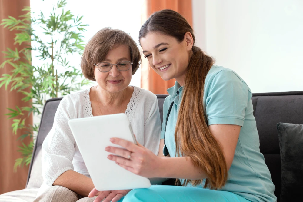 A couple receives companion care while seated on the couch with Thrive On Care.