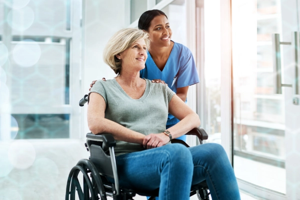 A caregiver provides light housekeeping while seated in a patient’s room through Thrive On Care.