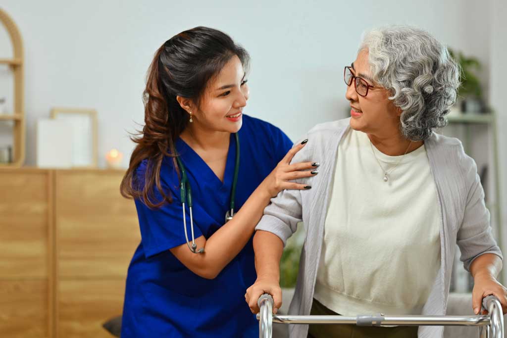 A caregiver from Thrive On Care helps with activities like games using a Wii controller.